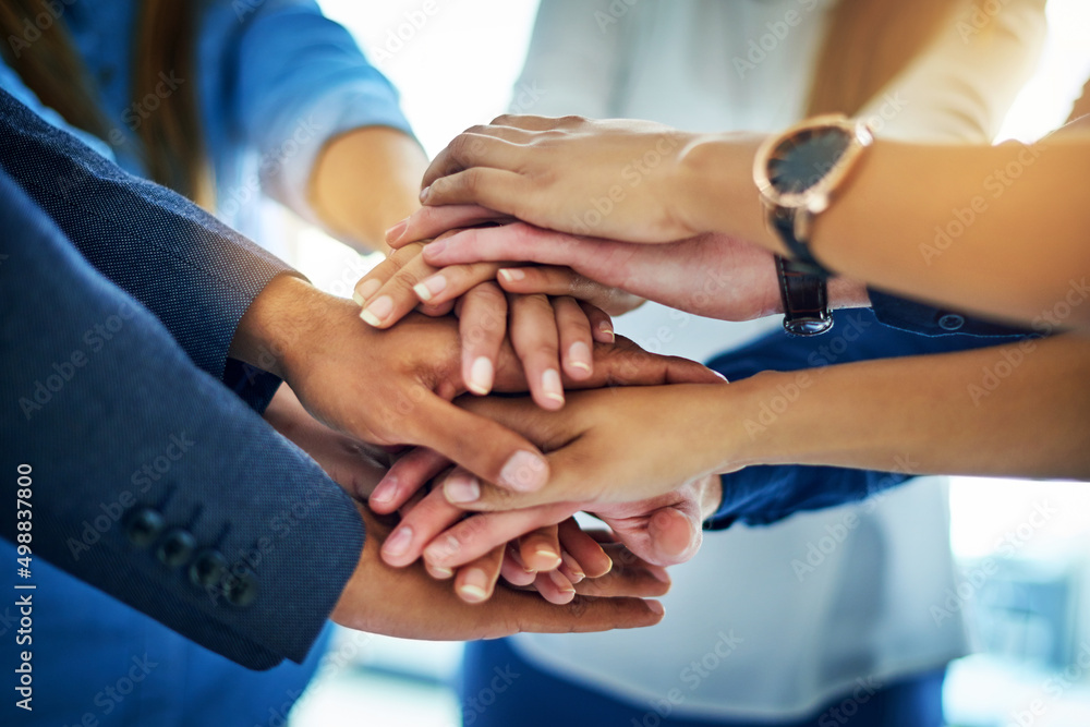 Poster as a team well go far. cropped shot of a group of unrecognizable businesspeople joining their hands 