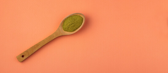 Organic green powder in wooden spoon - Moringa