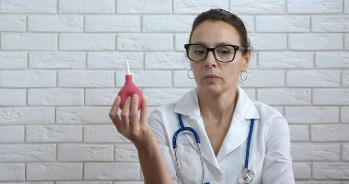 Nurse with enema. A view of enema in woman doctor hand.