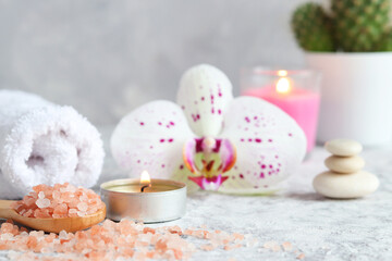 Pink himalayan salt, scented candle, orchid flower, zen stones and towel. Relaxing. Beauty and spa concept. Selective focus