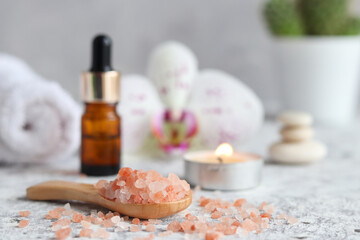 Massage set with pink himalayan salt, essential oil, scented candle, orchid flower, zen stones and towel. Beauty and spa concept. Selective focus
