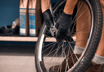 Hell get your wheels on the road again. Cropped shot of a man repairing a bicycle in a workshop.