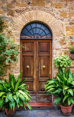 A wooden door with a half round frosted glass above