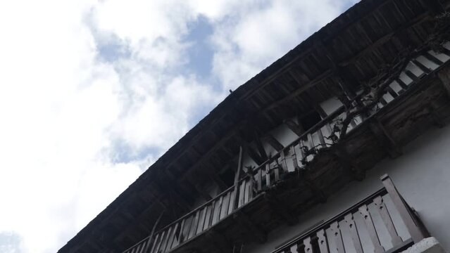 Time-lapse de nubes en el cielo con fachada de caser&iacute;o.