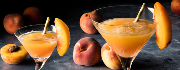 Narrow view of peach Bellini cocktails garnished with slices of peach.