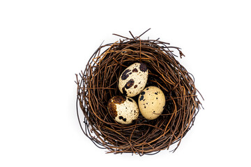 Obraz premium Raw quail eggs on a white background in a nest, top view, healthy eating concept