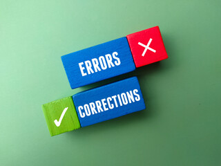 Top view colored wooden block with text CORRECTIONS ERRORS on green background.