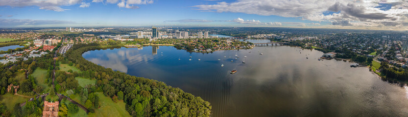 Naklejka premium Panoramic aerial drone view of Rhodes, an Inner West suburb of Sydney looking over McIlwaine Park and Brays Bay at Ryde Bridge along Parramatta River 