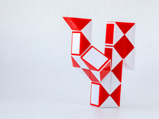 red and white bicolor magic snake Transformable twist puzzle in shape of cock isolated on white...