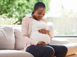 To be a mother. Cropped shot of an attractive young mother to be sitting on the sofa at home.
