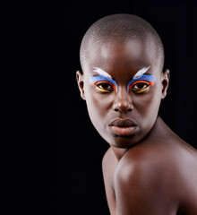A wild and colorful spirit. Studio portrait of a beautiful model posing with colorful eye makeup on a black background.
