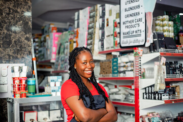Shot of a cheerful black african millennial woman posing proudly at camera with arm crossed.