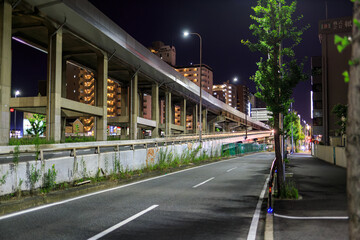 Empty street and elevated roadway through urban area at night