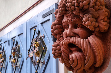 Close up of a Bacchus figure against blurred facade. Ancient statue , god of wine, fun and...