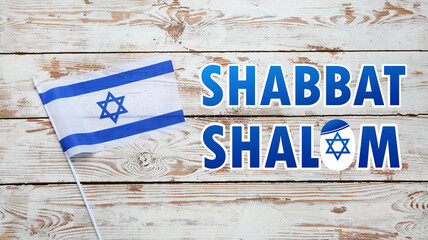 Flag of Israel and text SHABBAT SHALOM on wooden background - obrazy, fototapety, plakaty