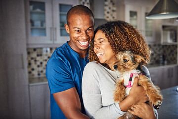 Hes simply the best. Cropped shot of an affectionate young couple standing with their puppy in the...
