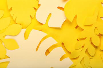 Paper tropical leaves on yellow background