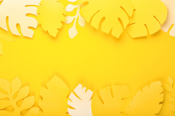 Paper tropical leaves on yellow background