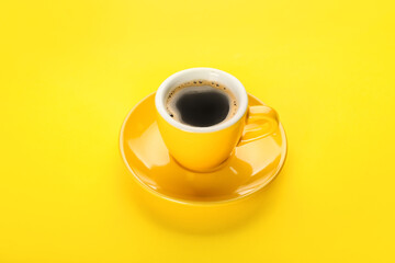 Cup of hot coffee on yellow background