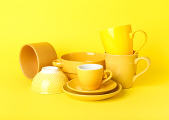 Set of clean tableware on yellow background