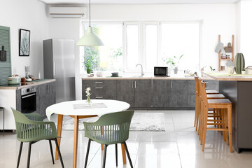 Dining table with chairs in modern interior of kitchen