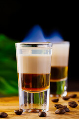 B-52 shot composed of three liqueurs. Shots of flaming B-52 cocktail placed on a bar counter.