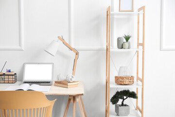 Modern workplace with laptop in room