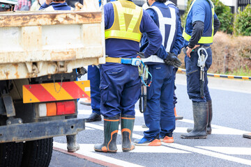 道路工事の始業前の打ち合わせをする作業員
