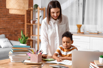 Little African-American boy studying Mathematics with tutor at home