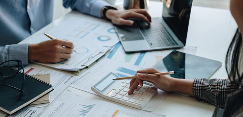 Financial adviser working with client, calculating and analyzing data paperwork chart for meeting...