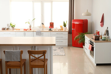 Stylish dining table, counters and new refrigerator in kitchen