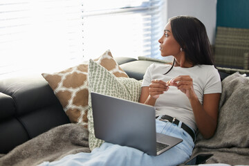 I always tend to zone out when Im at home. Shot of an attractive young woman sitting alone on her...