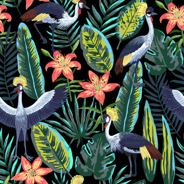 Vector seamless pattern with tropical jungle leaves and flowers and crowned crane birds. 