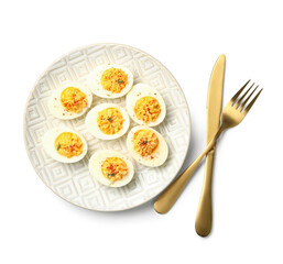 Plate with tasty stuffed eggs and cutlery on white background. Easter celebration