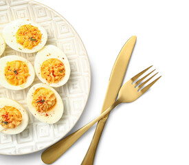 Plate with tasty stuffed eggs and cutlery on white background. Easter celebration