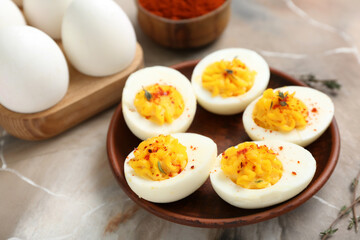 Plate with tasty stuffed eggs on grunge background, closeup. Easter celebration