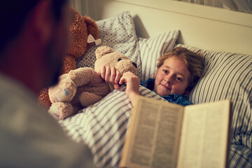 Magical stories to spark some sweetdreams. Cropped shot of a father reading a bedtime story to his little daughter at home. - obrazy, fototapety, plakaty