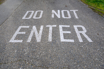 Do Not Enter stenciled on a sloping driveway in big white block letters
