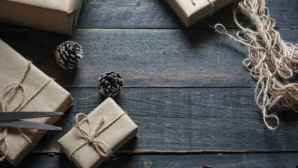 gift wrapping from Kraft paper wrapped with twine, the concept of handmade, placed on black wooden...
