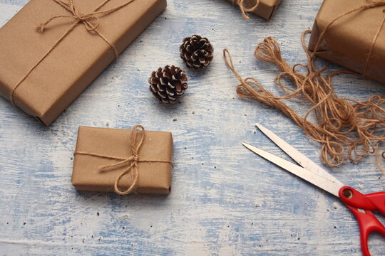 gift wrapping from Kraft paper wrapped with twine, the concept of handmade, light blue tabletop.