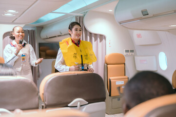 Air hostess and business people on passenger plane