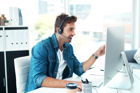 Yes Im looking at all the details right now. Shot of an attractive young call centre agent working in his office.