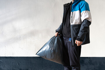 holding a plastic garbage bag, take out the trash