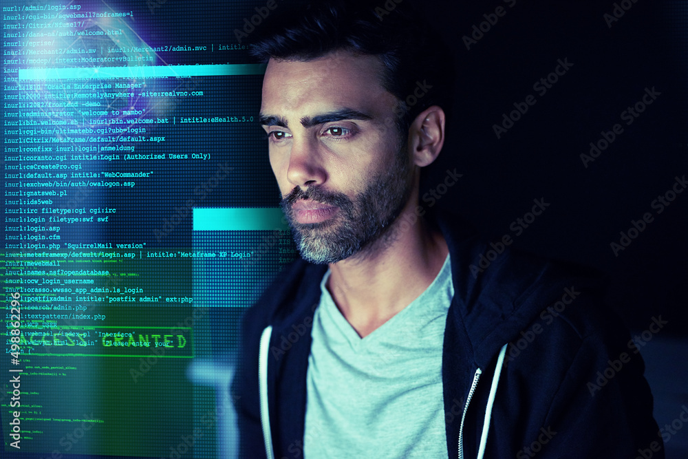 Poster Letting himself get lost in the code. Shot of a focussed computer hacker using a computer in the dark.