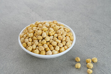 Chickpeas in white bowl on grey background. Space for text.
