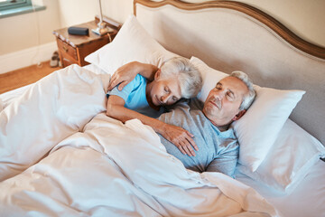 He still holds me until I fall asleep. Cropped shot of an affectionate senior couple cuddling each other while asleep in bed at a nursing home.