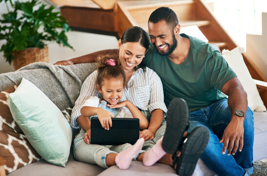 Sharing in the cutest connection. Shot of a happy family using a digital tablet together at home.