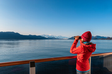 Vacation adventure. Alaska Glacier Bay cruise ship passenger looking at Alaskan mountains with binoculars exploring Glacier Bay National Park, USA. Woman on travel Inside Passage enjoying view - 498867899