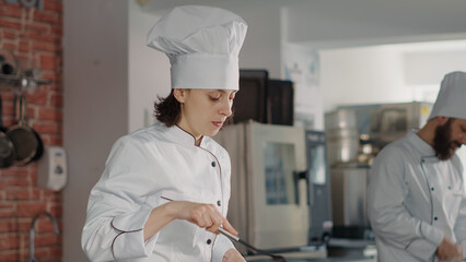 Gourmet chef cooking gastronomic dish in frying pan, wokring in restaurant kitchen. Professional cook making culinary recipe, preparing delicious cuisine dish with organic vegetables.