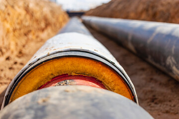 Insulated pipe. Large metal pipes with a plastic sheath laid in a trench. Modern pipeline for...